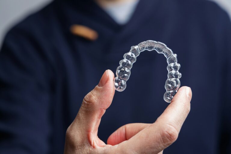 man holding one transparent aligner invisalign orthodontics concept