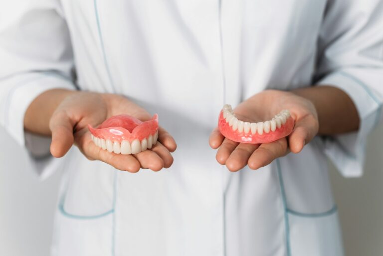 the dentist is holding dentures in his hands dental prosthesis in the hands of the doctor close up