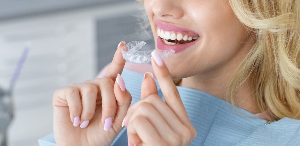 unrecognizable female patient holding invisible braces or trainer panorama