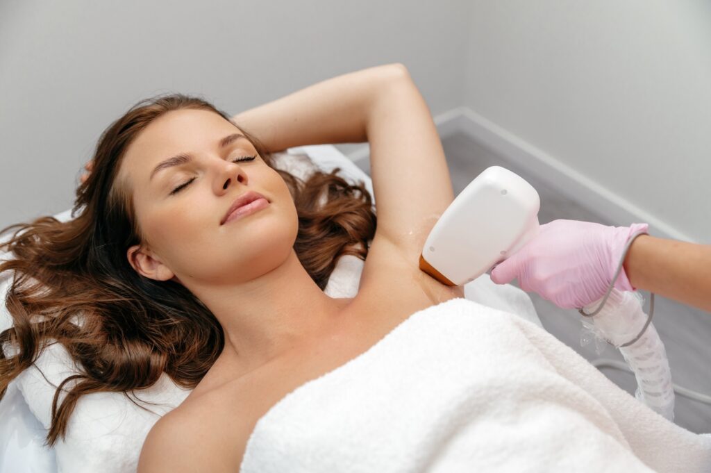 beauty procedure hair removal by laser hair removal caucasian young woman lies on the couch with