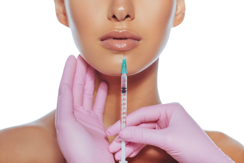 cropped sensual female lips procedure lip augmentation syringe near womans mouth