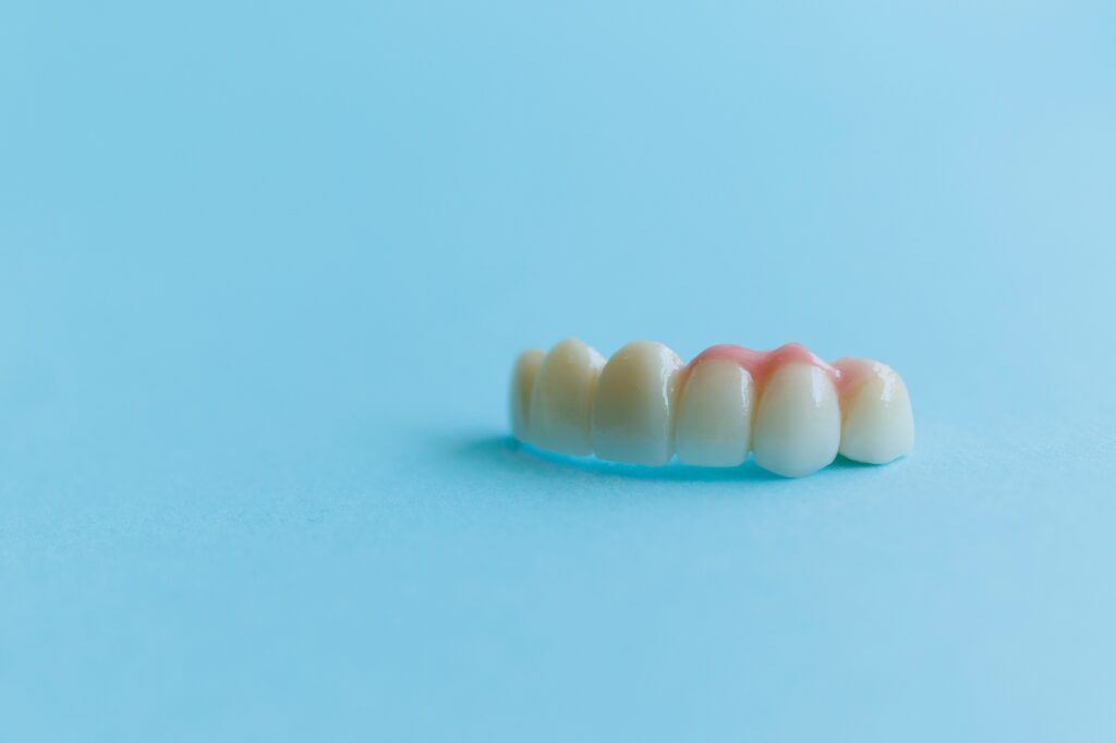 artificial teeth on a blue background dental crowns concept of dental implantation and restoration