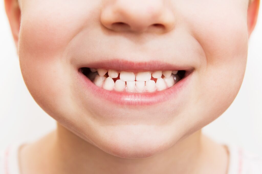 baby smile close child teeth on a white isolated background