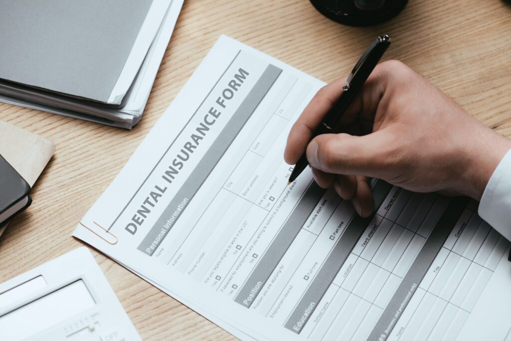 cropped view of man filling in dental insurance form dentist concept