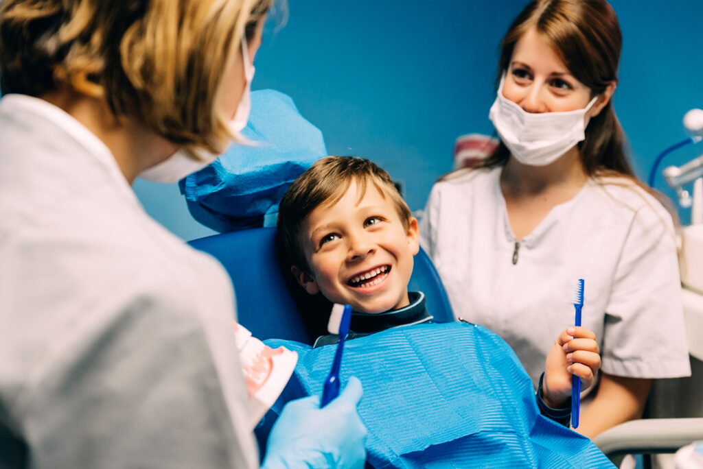 doctor dentist teaching a child to brush teeth