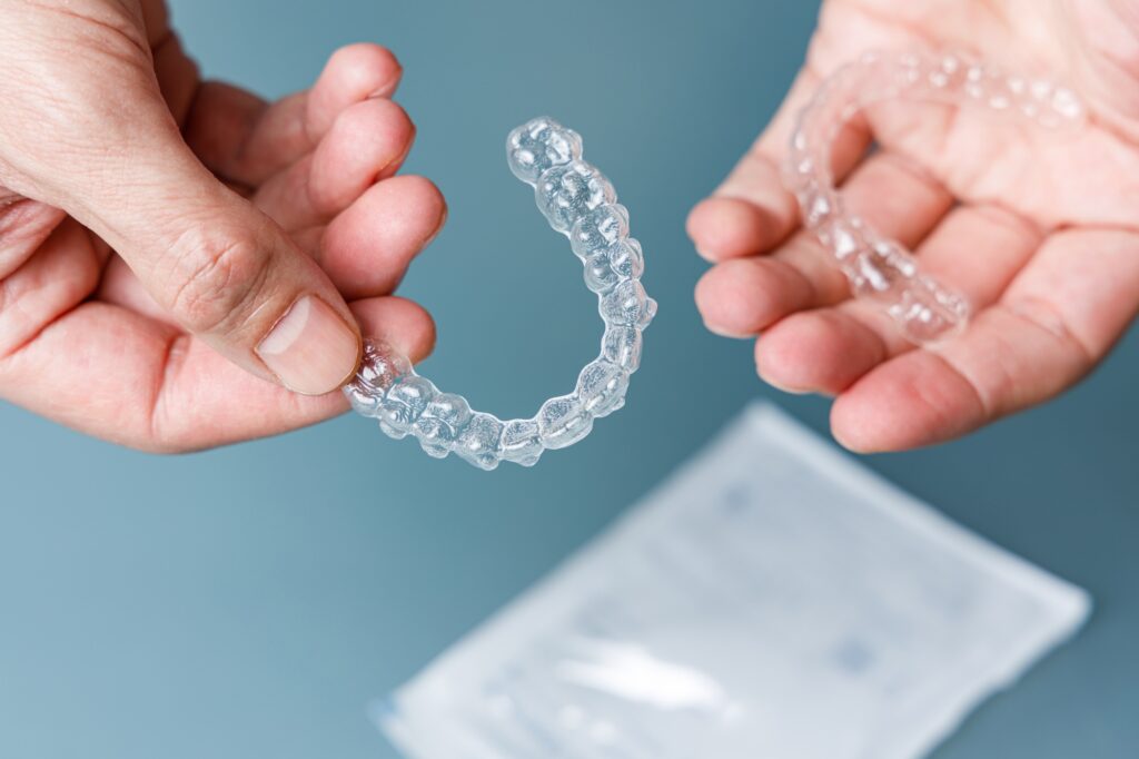 hands holding transparent aligners invisalign orthodontics concept