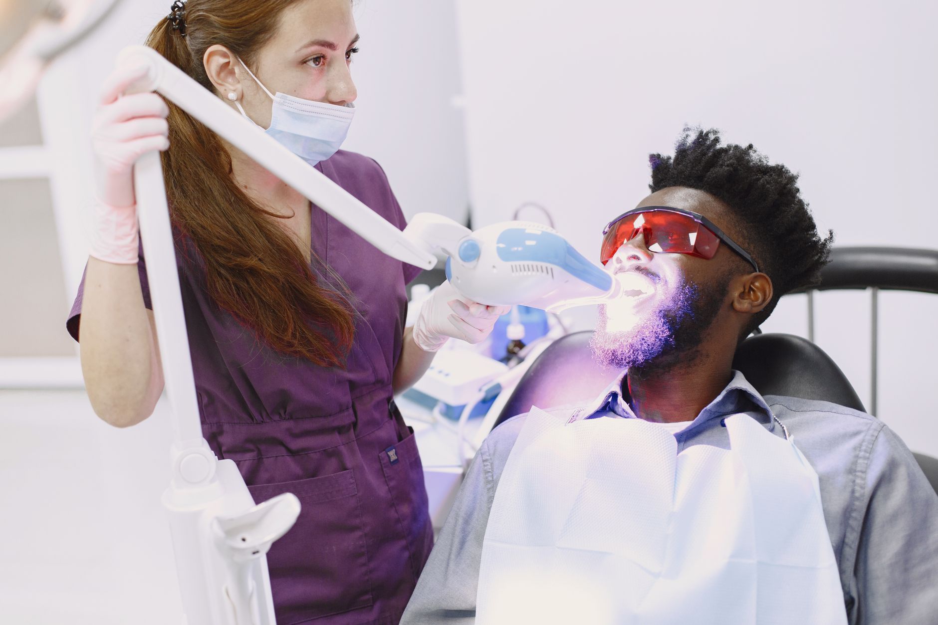 dental professional performing in-office teeth whitening treatment
